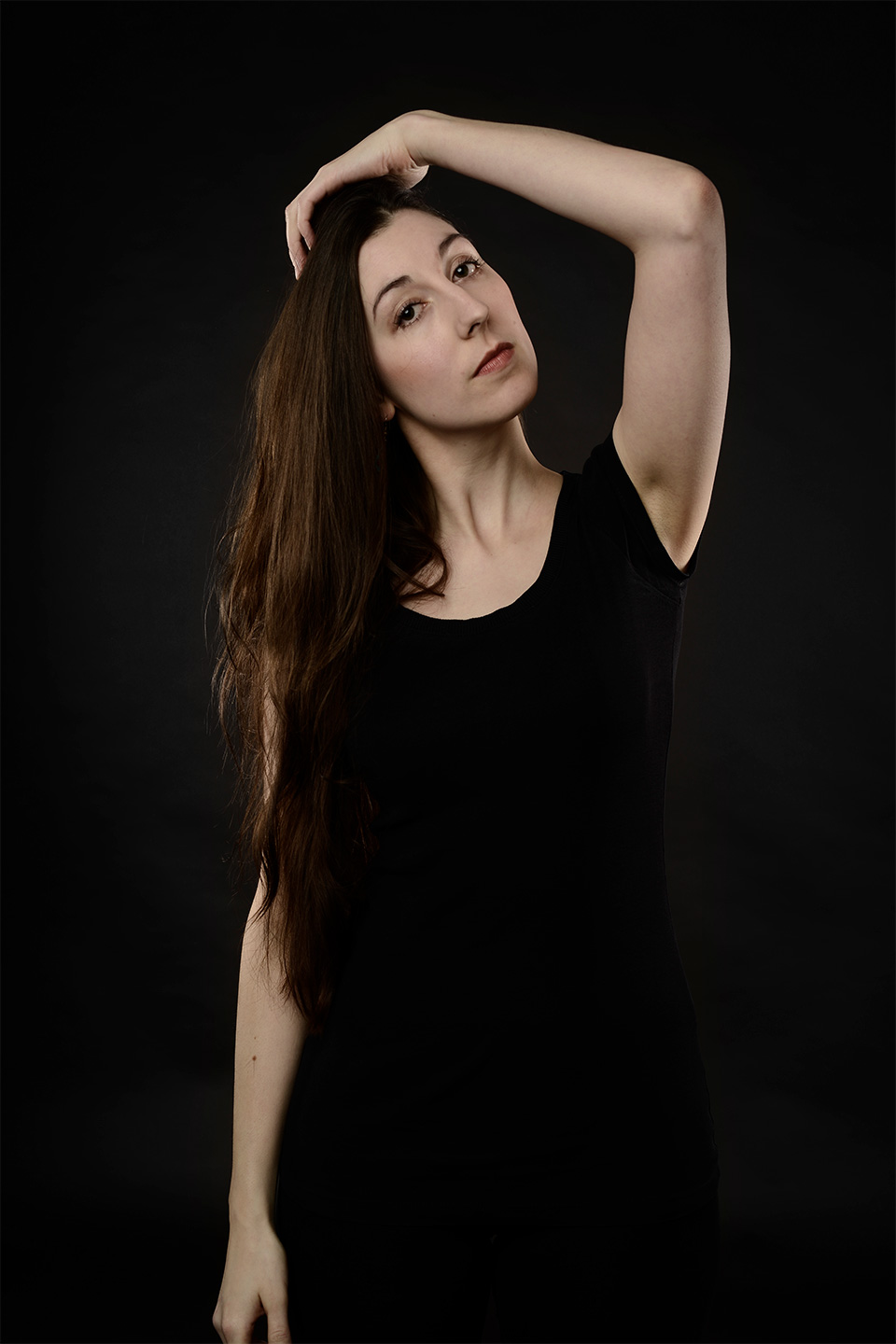 Rahel Schöppenthau, wearing a black top, one hand touches her head